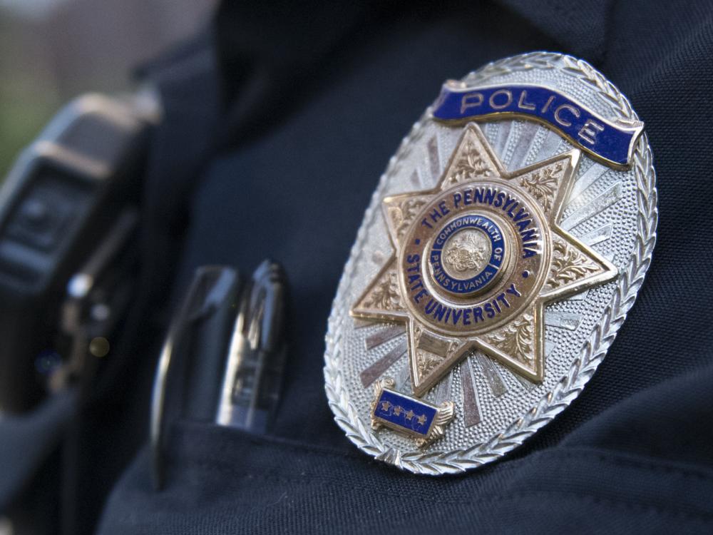 Police officer shoulder shown with metal badge on arm.